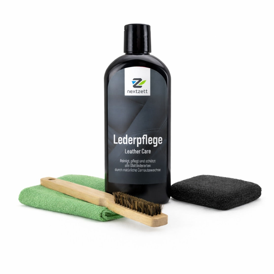 Leather care product set with bottle, brush, cloth, and pad on a white background