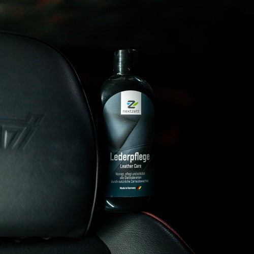 Bottle of leather care product on a car seat with 'nextzett' branding.