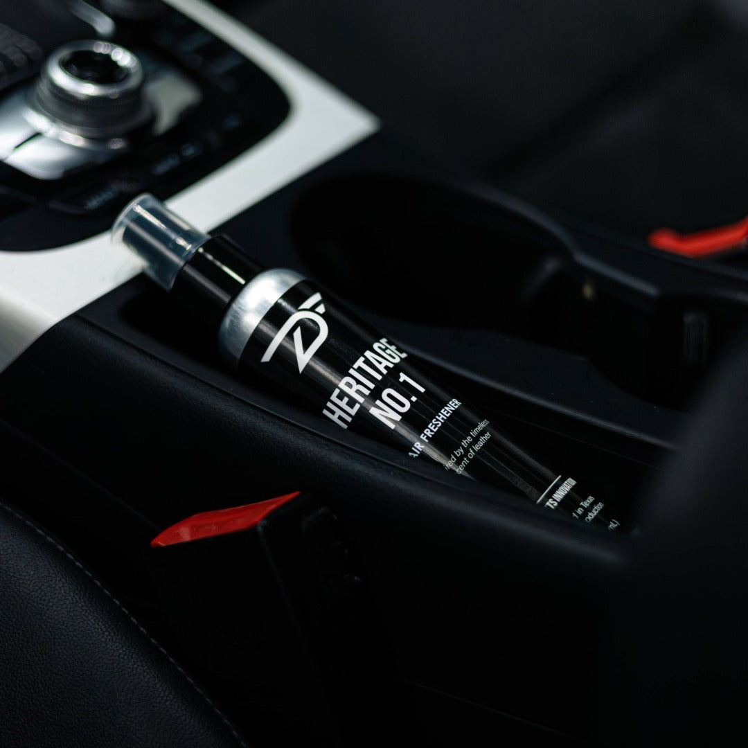 Car interior with a bottle labeled 'Heritage No.1' on the dashboard.