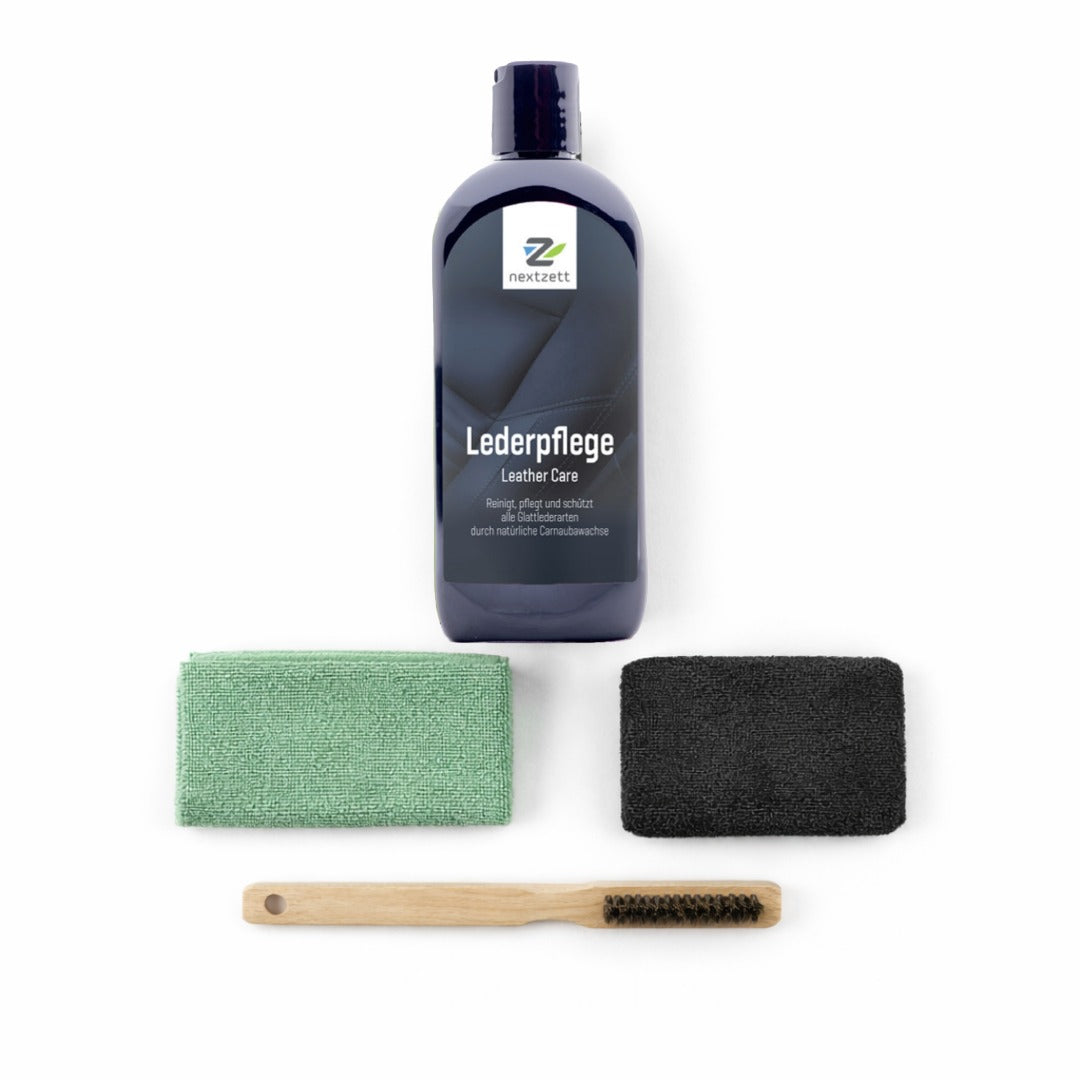 Leather care product set with bottle, brush, and cloths on a white background