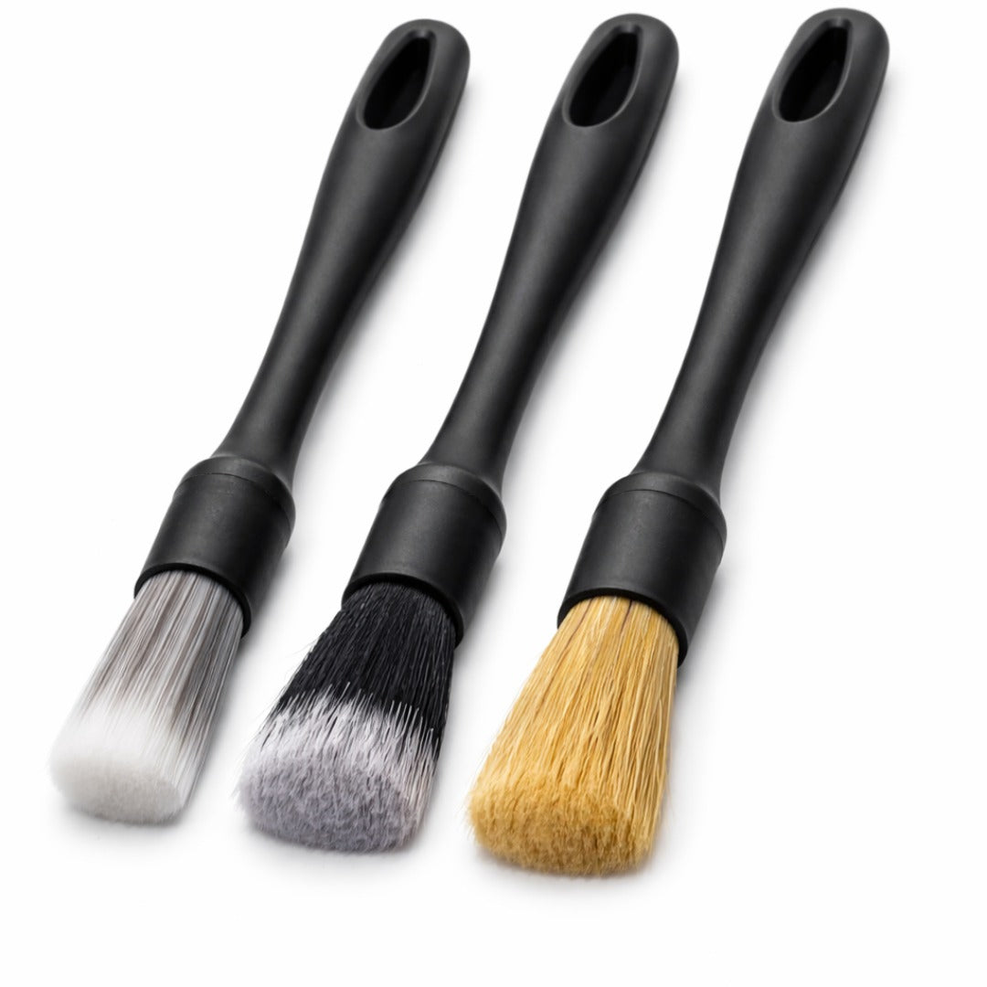 Three black-handled brushes with different bristle types on a white background