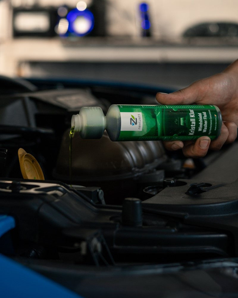 Pouring nextzett Kristall Klar Windshield Washer fluid concentrate into car washer tank